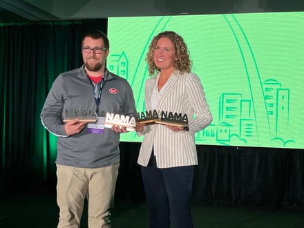 A man and a woman holding awards